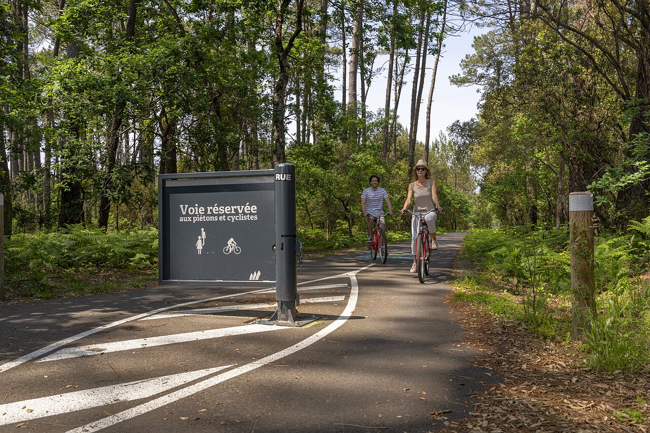 Pareja en bicicleta por carril bici en bosque, camping CAPFUN Clown Oc�an, TOSSE (40).