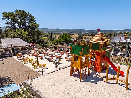 Zona de juegos castillo y terraza restaurante exterior en el camping CLICOCHIC Commanderie en Rustiques (11).