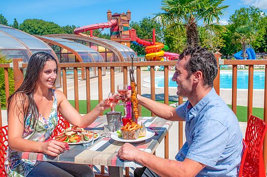 Pareja cenando, toboganes acu�ticos en camping CAPFUN Coquelicots en Royan (17).