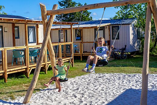 Niños jugando en los columpios, Mobil-homes en el camping VAGUES OCEANES Coq Hardi.