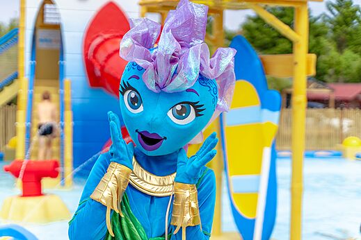 Mascota azul sonriente en el espacio acuático del camping VAGUES OCEANES Coq Hardi.