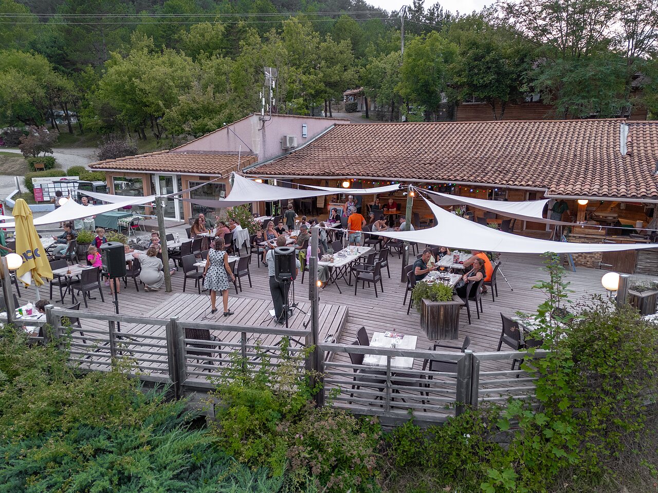 Terraza de restaurante animada con espect�culo en vivo en camping CLICOCHIC Couriou (26).
