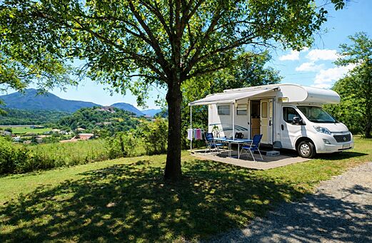 Autocaravana en parcela sombreada con mesa en camping CLICOCHIC Couriou (26).