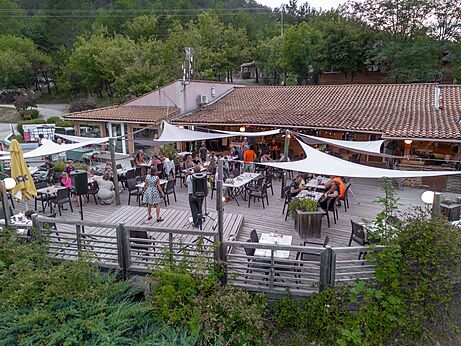 Terraza de restaurante animada con espectáculo nocturno en el camping CLICOCHIC Couriou en Recoubeau-Jansac.