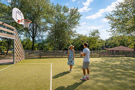 Cancha multideporte con canasta de baloncesto en el camping CLICOCHIC Couriou (26).