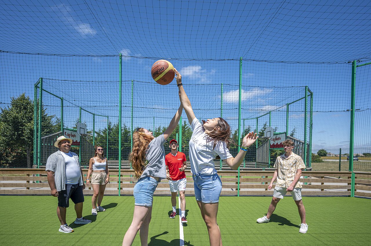 Dos j�venes juegan baloncesto en cancha multideporte en camping CAPFUN Curty's en Jard sur Mer (85).