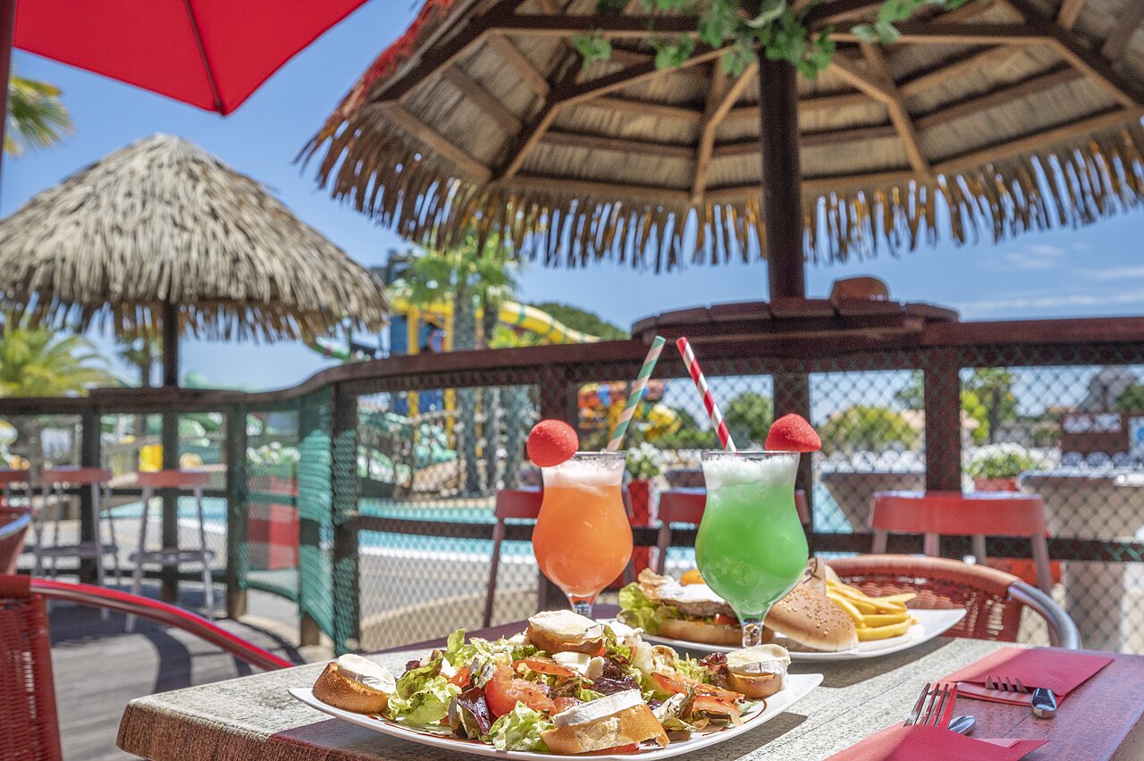 Platos y c�cteles en la terraza del restaurante con piscina en el camping CAPFUN Curty's en Jard sur Mer (85).