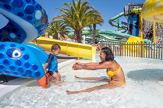 Piscina con toboganes, niño y madre en el camping CAPFUN Curty's en Jard sur Mer (85).