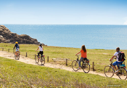 Familia en bicicleta por sendero costero junto al mar en camping CAPFUN Dauphins Bleus en GIVRAND (85).