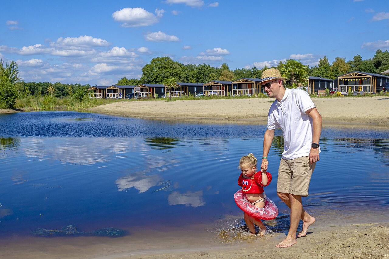Padre e hijo en el lago, playa y alojamientos en el camping CAPFUN De Belten en Rheeze.