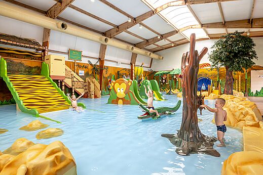 Piscina cubierta lúdica con toboganes y juegos de agua en el camping CAPFUN De Belten en Rheeze.