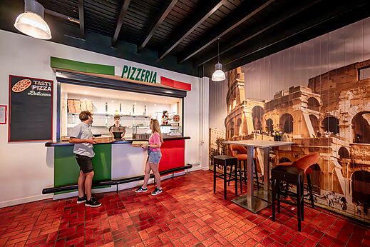 Pizzería moderna con mostrador de servicio y clientes en el camping CAPFUN De Belten a Rheeze.