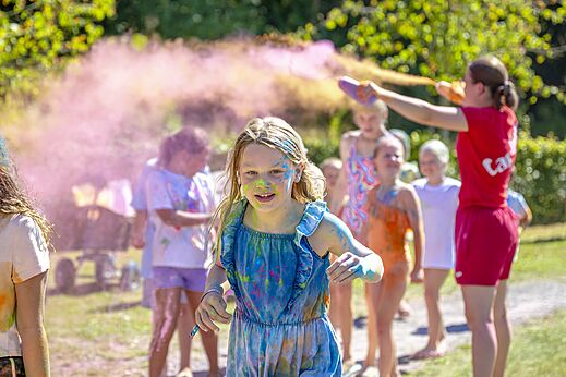 Niños felices en una actividad de polvos de colores en el camping CAPFUN De Belten en Rheeze.
