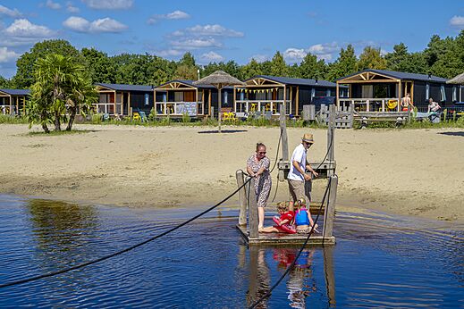 Familia en balsa tirando cuerda, playa y Mobil-homes en camping CAPFUN De Belten en Rheeze.
