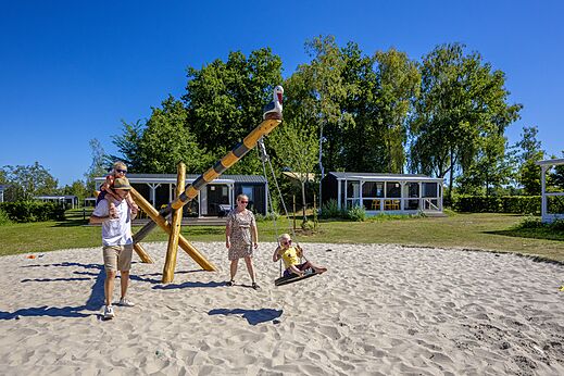 Zona de juegos con columpio y familia en el camping CAPFUN De Belten en Rheeze.