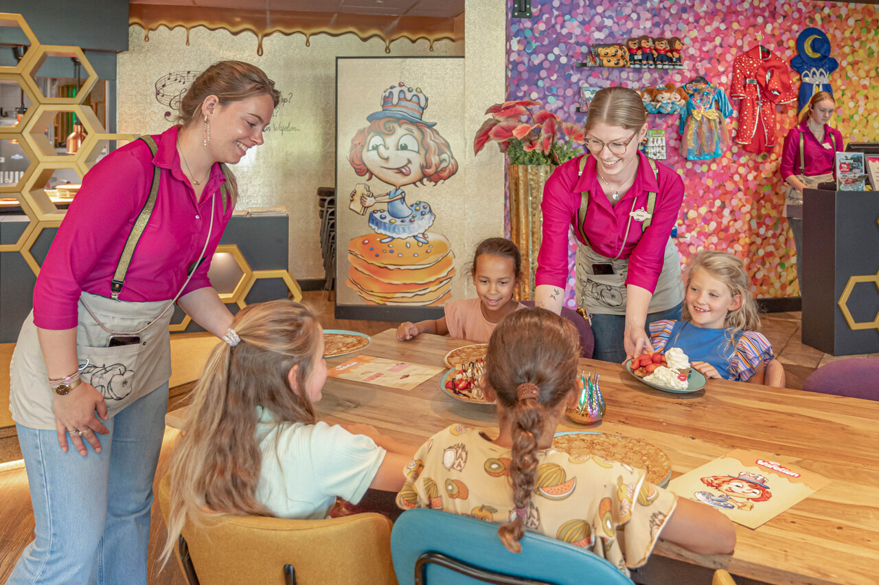 Personal sonriente sirve crepes a ni�os en restaurante CAPFUN De Bongerd Tuitjenhorn.