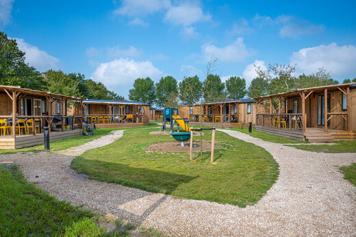 Casas móviles de madera con terrazas y zona de juegos en el camping CAPFUN De Bongerd a Tuitjenhorn.