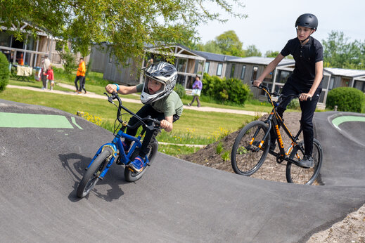 Niños en bicicleta en pista pumptrack del camping CAPFUN De Bongerd en Tuitjenhorn.