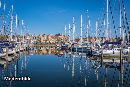 Puerto deportivo con veleros y casas históricas en Medemblik, Países Bajos.