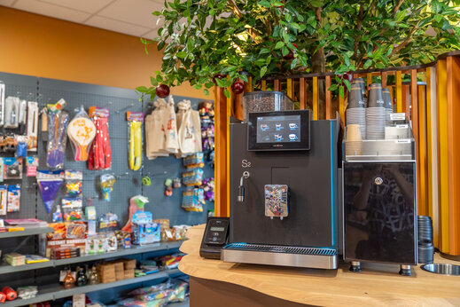 Máquina de café y estantes de la tienda de comestibles en el camping CAPFUN De Bongerd en Tuitjenhorn.