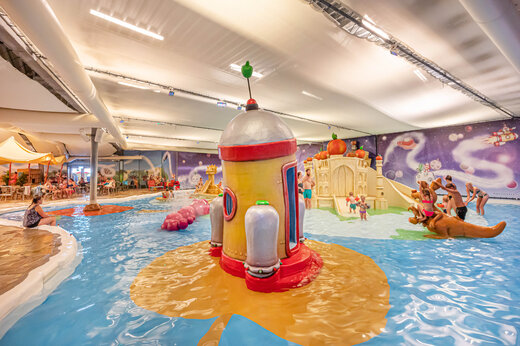Piscina cubierta con juegos acuáticos y toboganes en camping CAPFUN De Bongerd Tuitjenhorn.