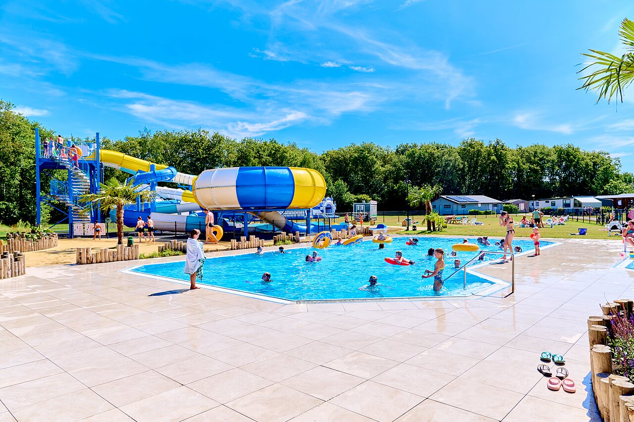 Toboganes acu�ticos y piscina exterior con gente en el camping CAPFUN De Eikenhof en Paasloo/Oldemarkt.