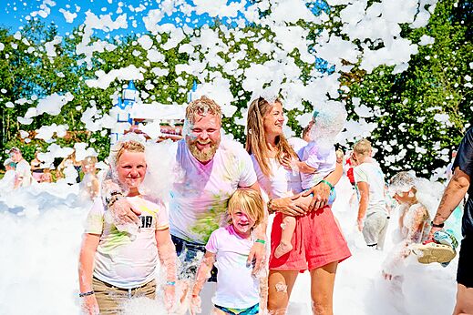 Familia feliz disfrutando de una fiesta de espuma en el camping CAPFUN De Eikenhof en Paasloo/Oldemarkt.