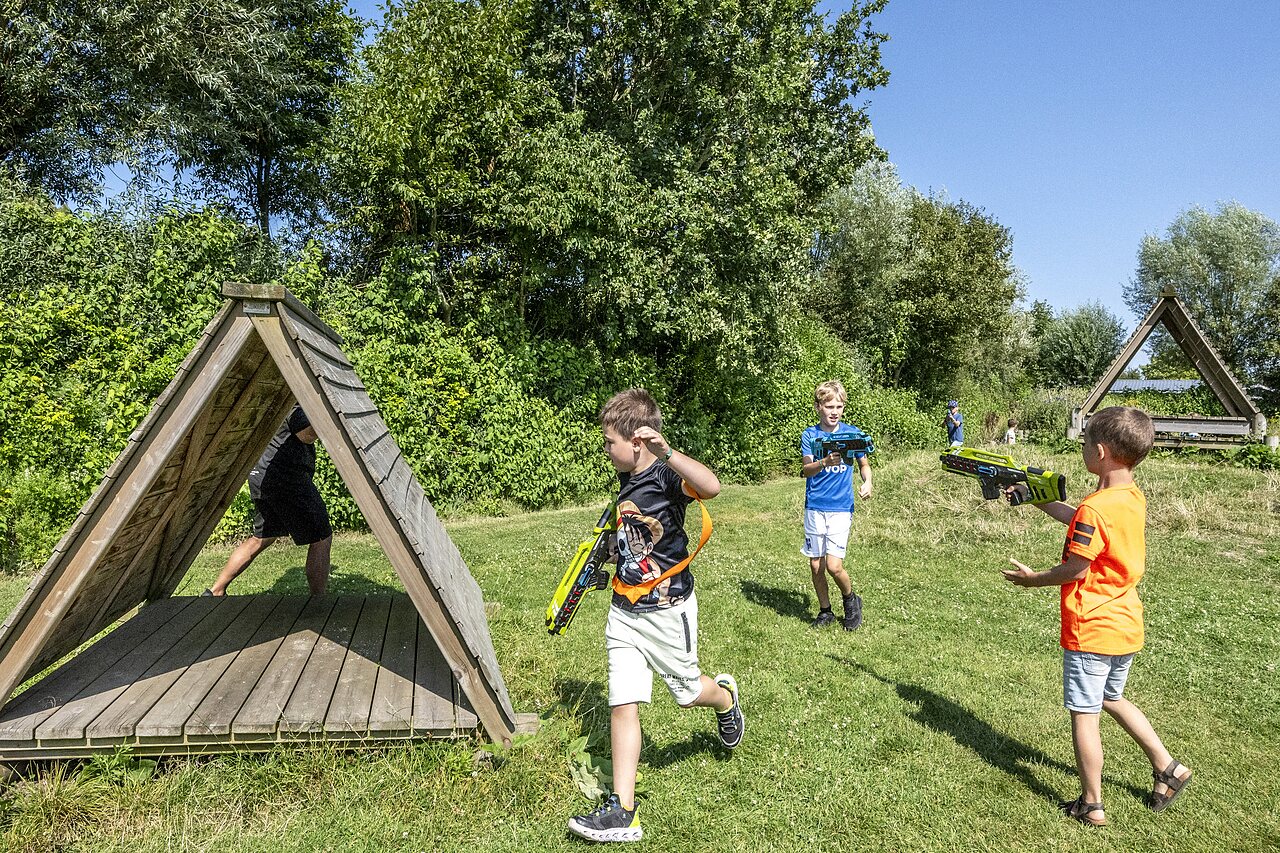 Ni�os jugando al laser tag al aire libre en el camping CAPFUN De Pekelinge en Oostkapelle.
