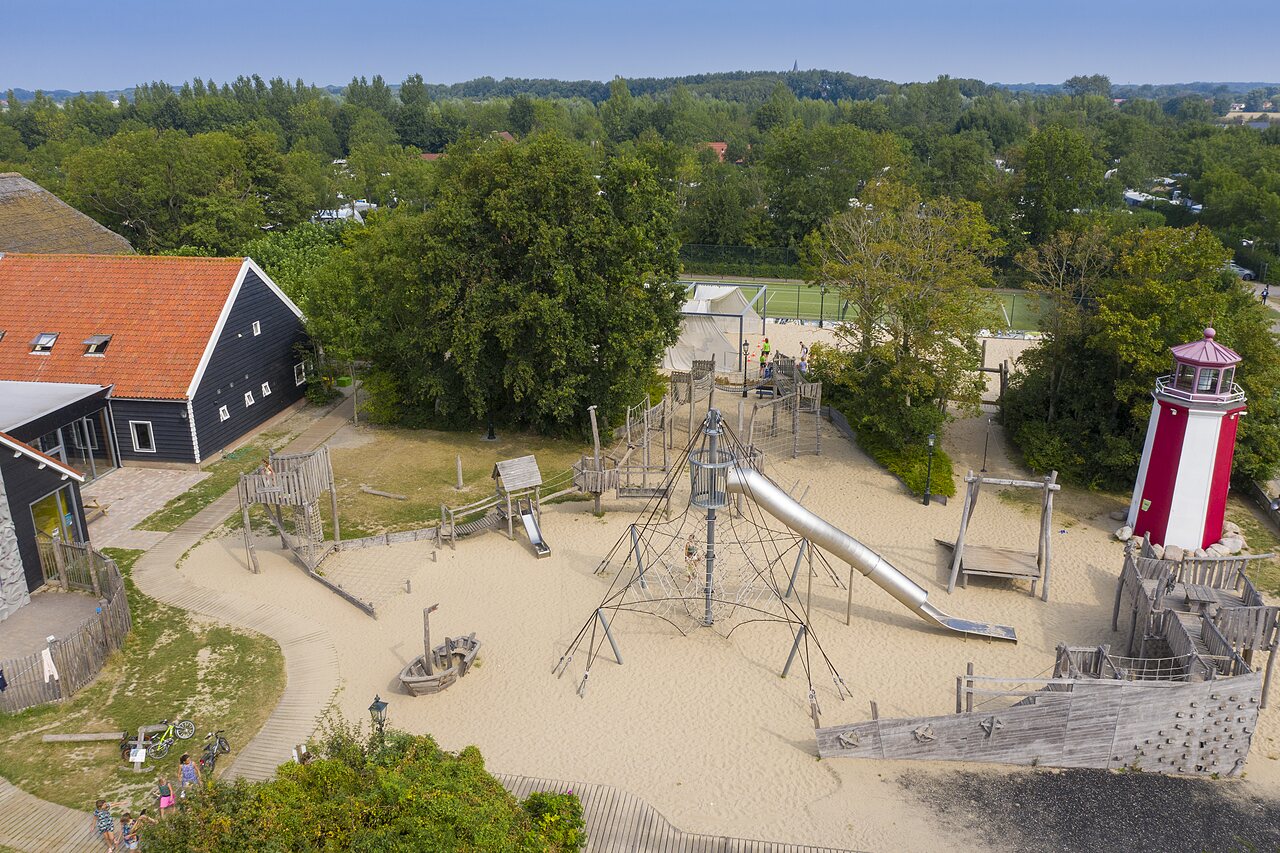 Gran parque infantil de arena, tobog�n, faro en el camping CAPFUN De Pekelinge en Oostkapelle.