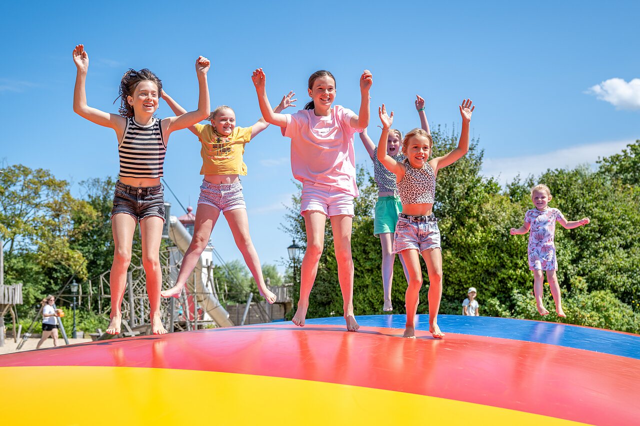 Ni�os saltando en cama el�stica hinchable gigante en camping CAPFUN De Pekelinge en Oostkapelle.