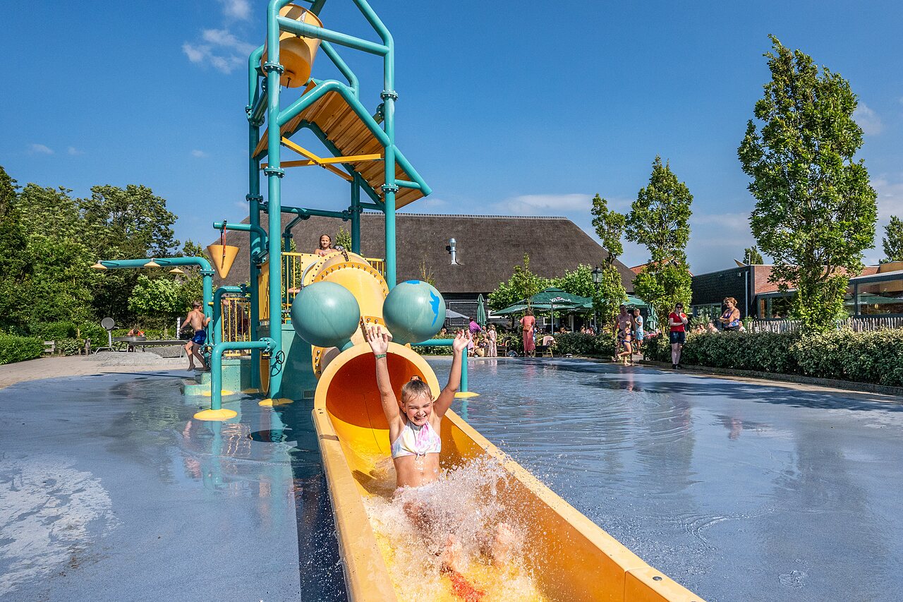 Ni�a en tobog�n acu�tico, juegos de agua en el camping CAPFUN De Pekelinge en Oostkapelle.