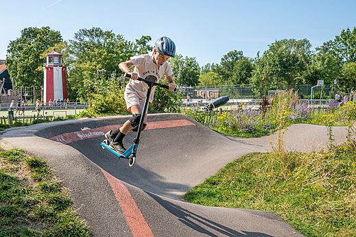 Niño en patinete en pump track del camping CAPFUN De Pekelinge en Oostkapelle.