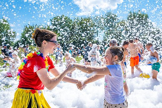 Divertida animación de espuma con niños y animadora en el camping CAPFUN De Pekelinge en Oostkapelle.
