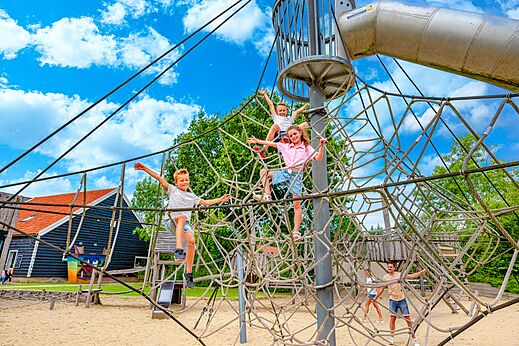Ni�os escalando red y tobog�n gigante en el camping CAPFUN De Pekelinge en Oostkapelle.