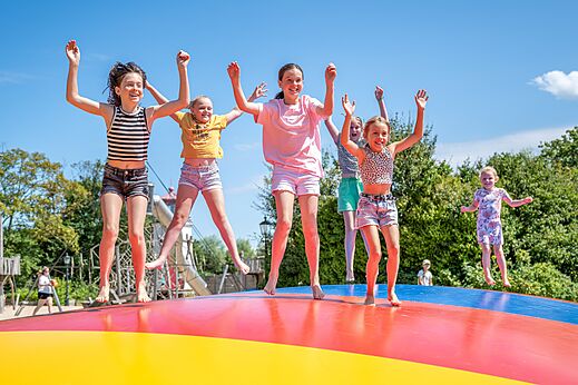 Niños saltando en cojín hinchable colorido, camping CAPFUN De Pekelinge en Oostkapelle.