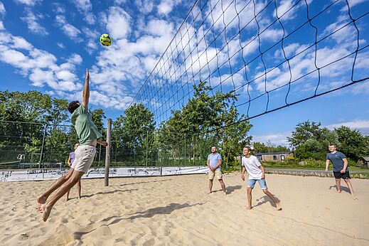 Jugadores de voleibol de playa en cancha de arena en el camping CAPFUN De Pekelinge en Oostkapelle.