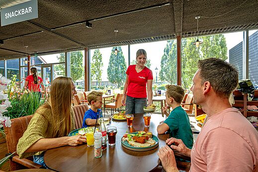 Familia almorzando en el snack-bar del camping CAPFUN De Pekelinge en Oostkapelle.