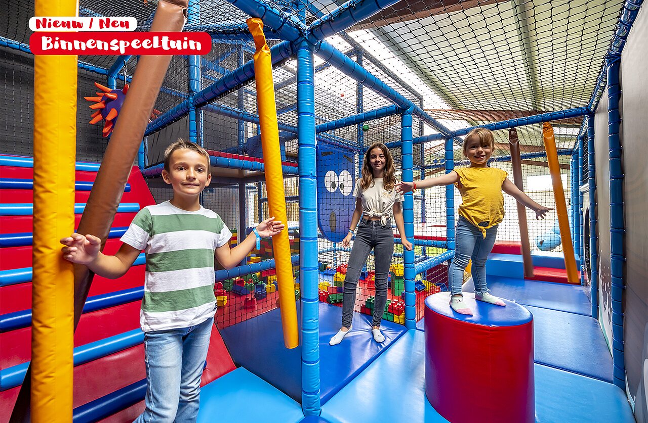Parque infantil cubierto colorido con ni�os sonrientes en el camping CAPFUN De Rotonde en Enspijk.