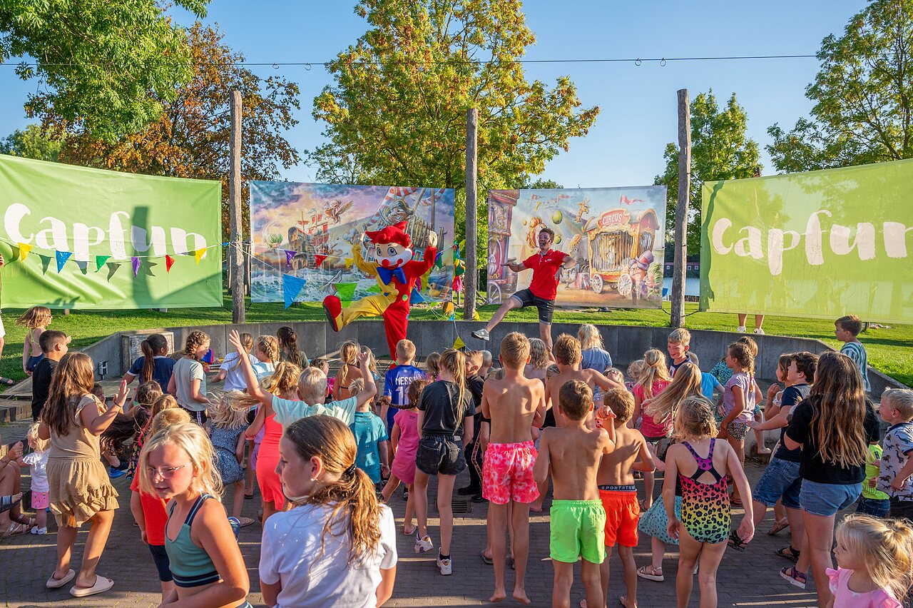 Ni�os disfrutando de animaci�n con animador y mascota en el camping CAPFUN De Rotonde en Enspijk.