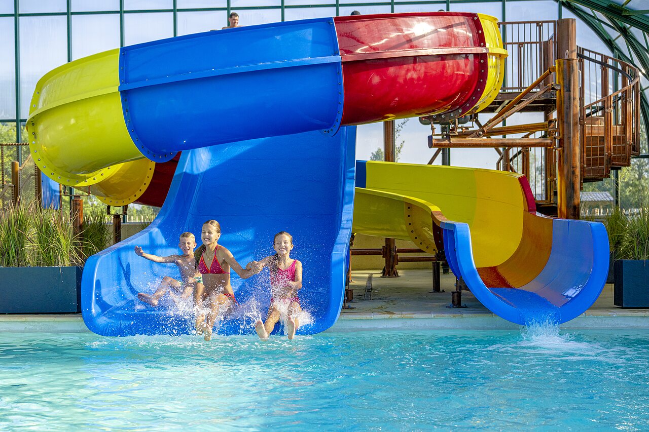 Toboganes acu�ticos y piscina con ni�os riendo en el camping CAPFUN De Rotonde en Enspijk.