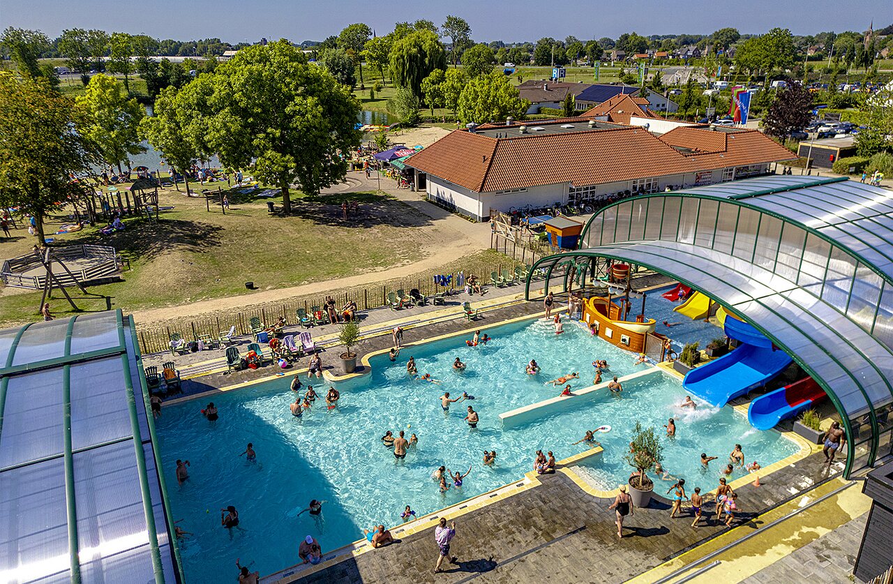 Piscina cubierta y exterior con toboganes, juegos acu�ticos en el camping CAPFUN De Rotonde en Enspijk.