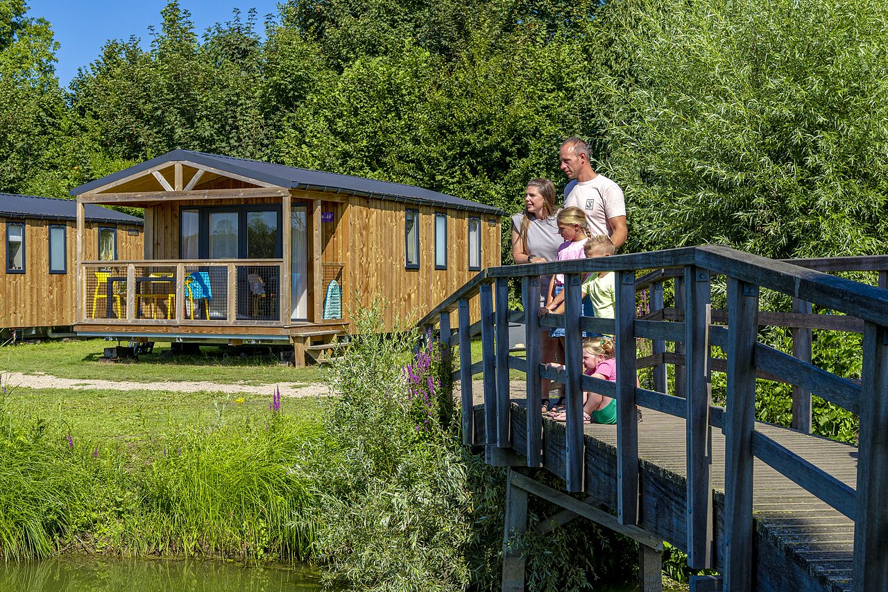 Familia en puente de madera, casas m�viles, naturaleza en el camping CAPFUN De Rotonde en Enspijk.