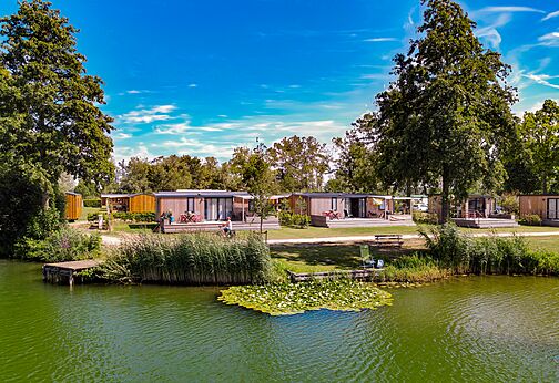 Modernos Mobil-homes junto a un lago verde en el camping CAPFUN De Rotonde en Enspijk.