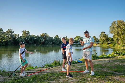 Pesca en familia a orillas del lago en el camping CAPFUN De Rotonde en Enspijk.