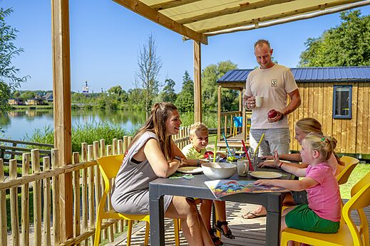 Familia en terraza de Mobil-home en camping CAPFUN De Rotonde en Enspijk.