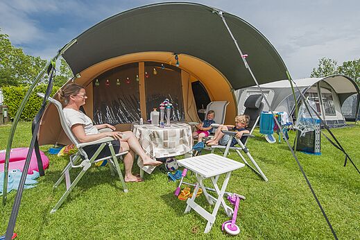 Familia en parcela de camping con tienda grande en el camping CAPFUN De Rotonde en Enspijk.