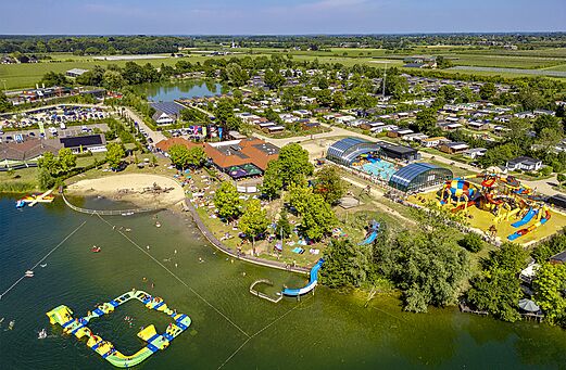 Vista aérea lago, parque acuático y juegos en el camping CAPFUN De Rotonde en Enspijk.