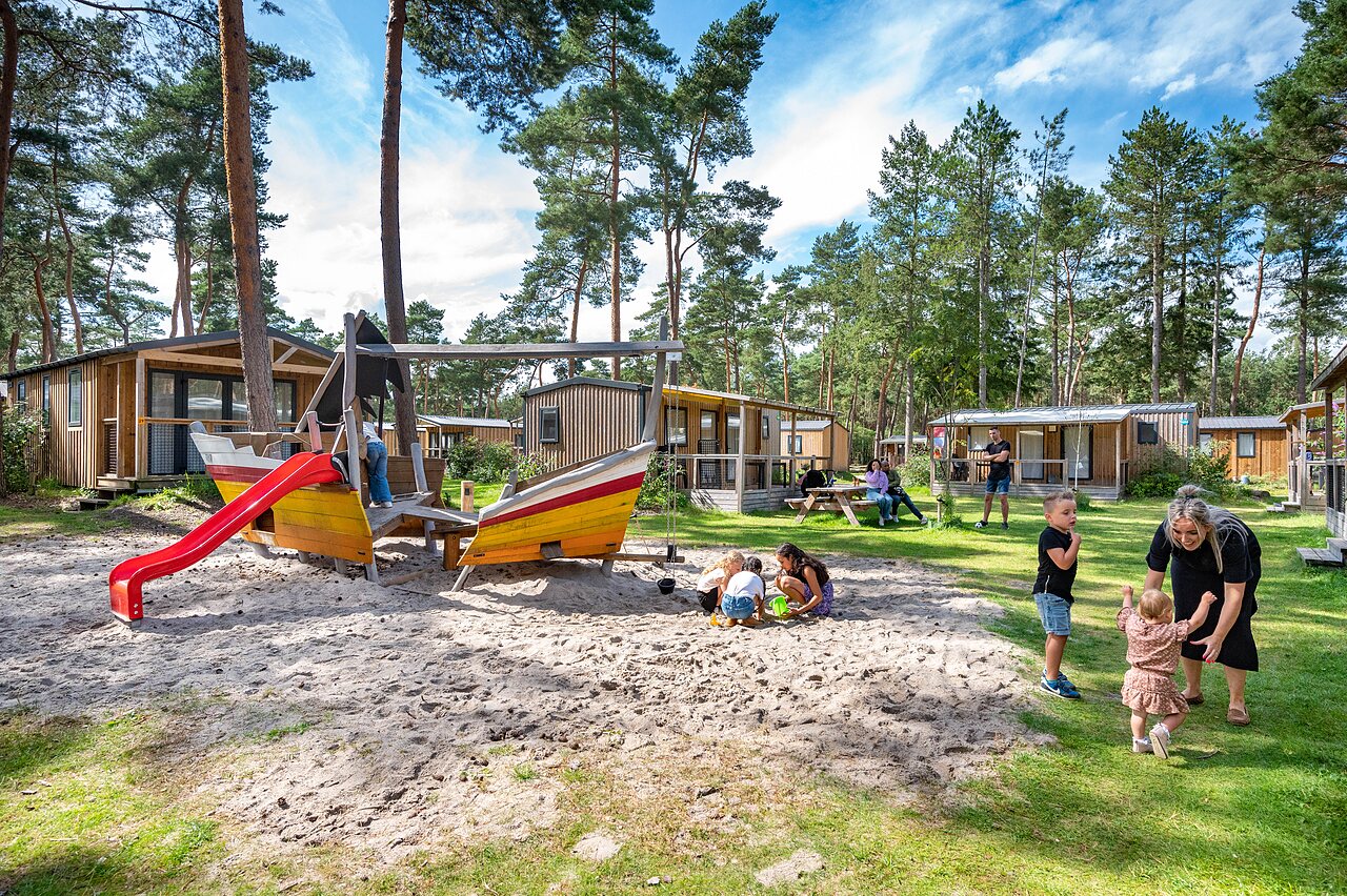 Zona de juegos con barco y tobog�n, ni�os jugando en el camping CAPFUN De Scheepsbel en Doornspijk.