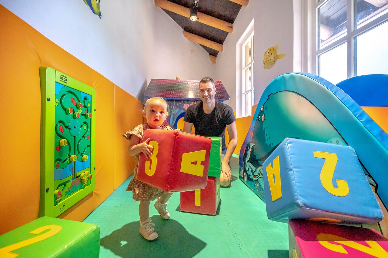 Zona de juegos interior con beb� y adulto en el camping CAPFUN De Scheepsbel en Doornspijk.