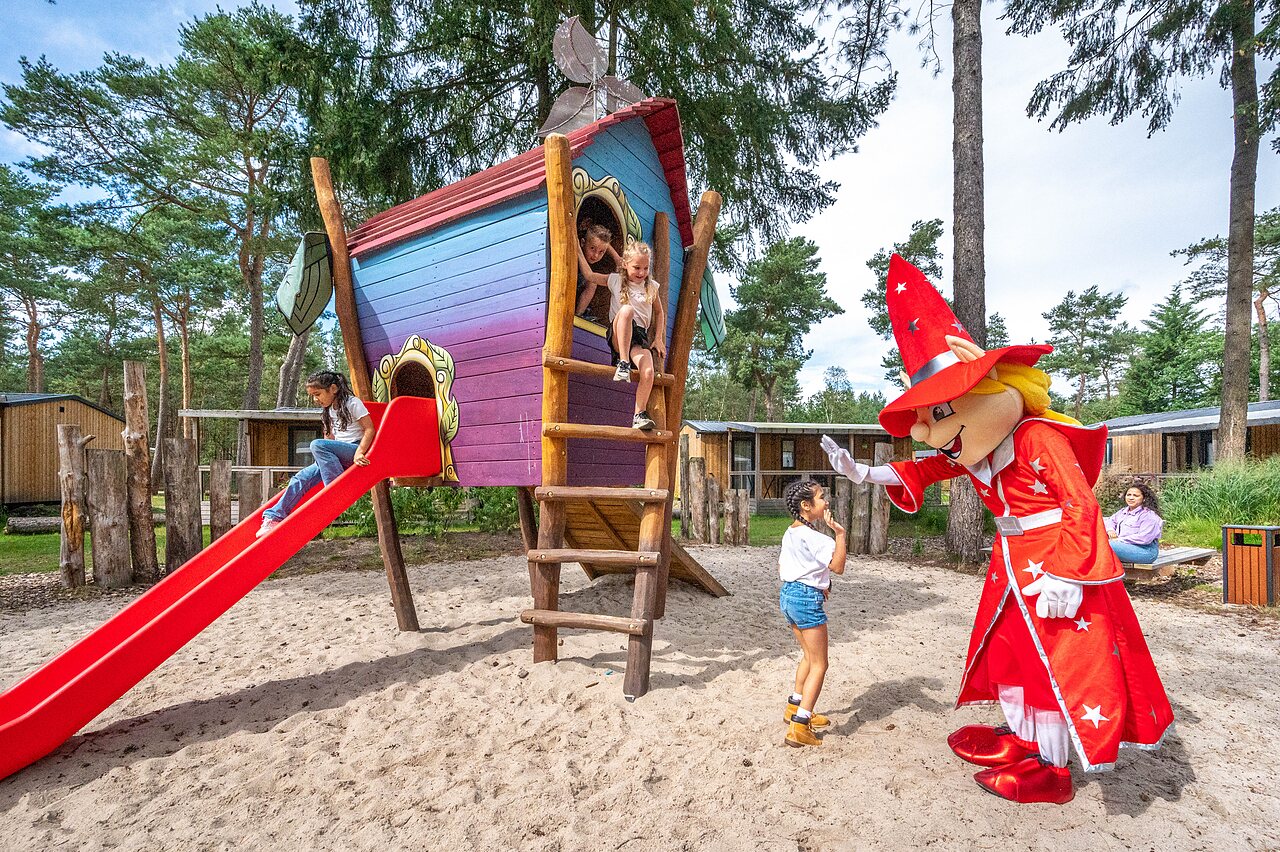 Zona de juegos con tobog�n, caba�a y mascota en el camping CAPFUN De Scheepsbel en Doornspijk.